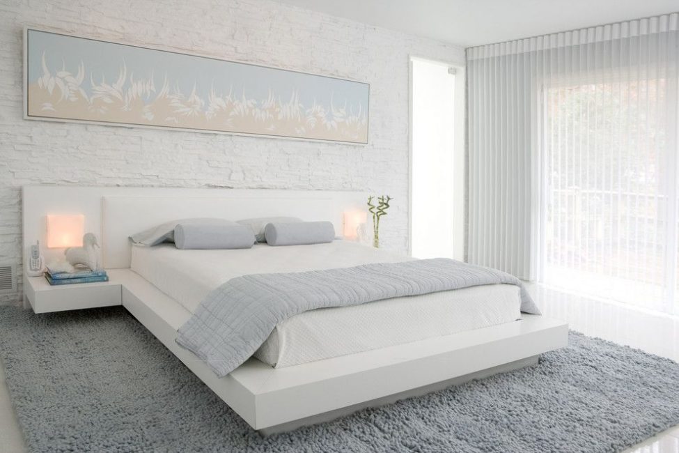 Hvit seng i interiøret gir en følelse av letthet