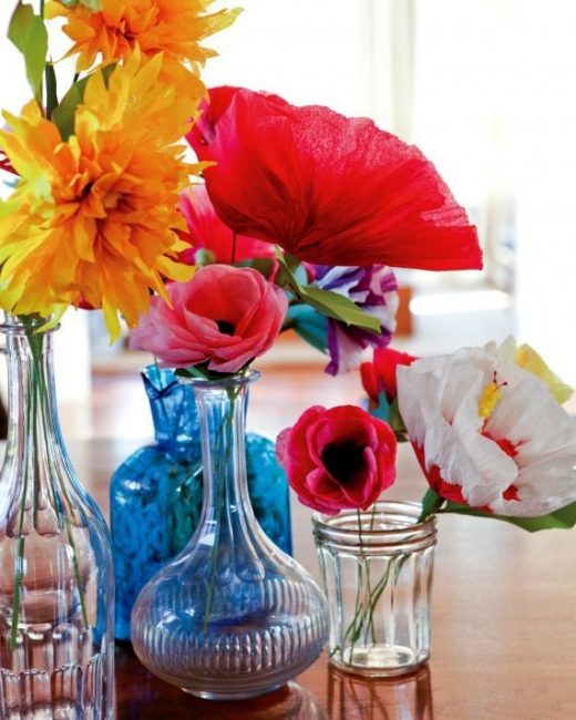 Večbarvno cvetje v steklenih posodah