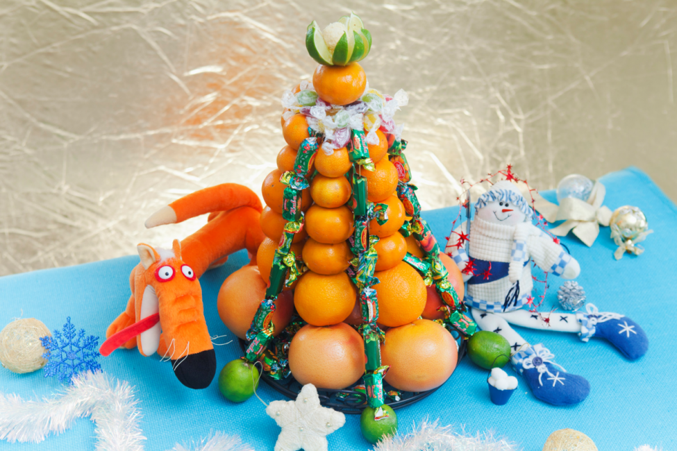 Árbol de Navidad de diseño hecho de frutas y dulces.