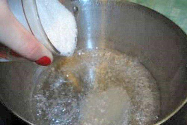 Zucker in das erhitzte Wasser geben
