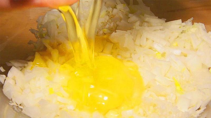 أضف بيضة إلى البصل المفروم