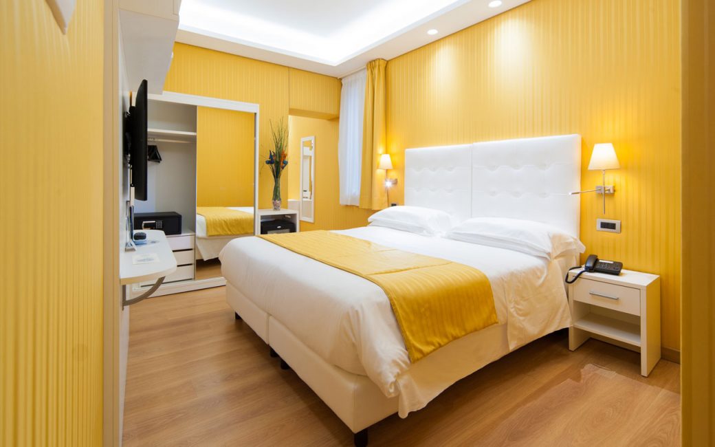 Gula nyanser på väggarna i sovrummet gör det mer rymligt, bekvämt och lättare.
