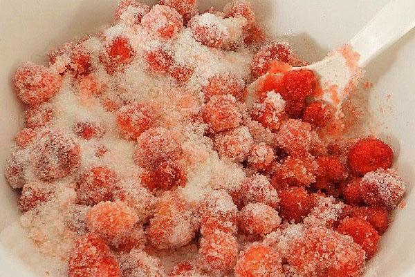 Erdbeeren mit Zucker mischen