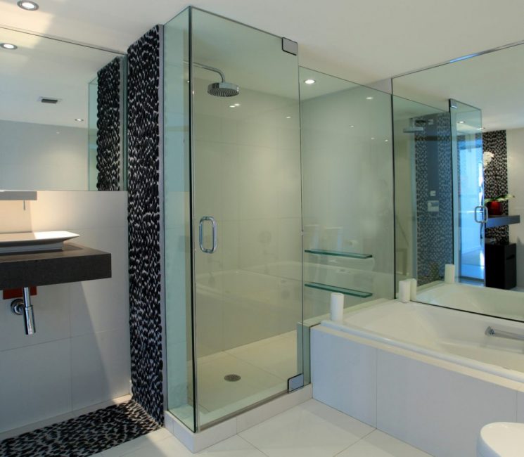 Cabine de duche em vidro em conjunto com um espelho